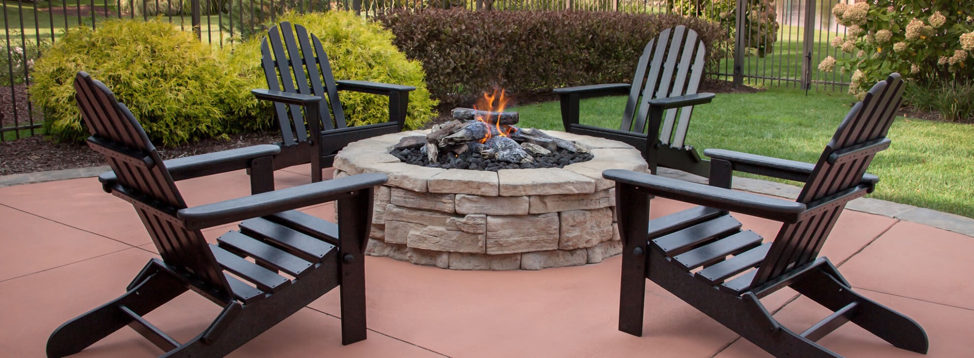 Black Adirondack Chairs around a fire pit